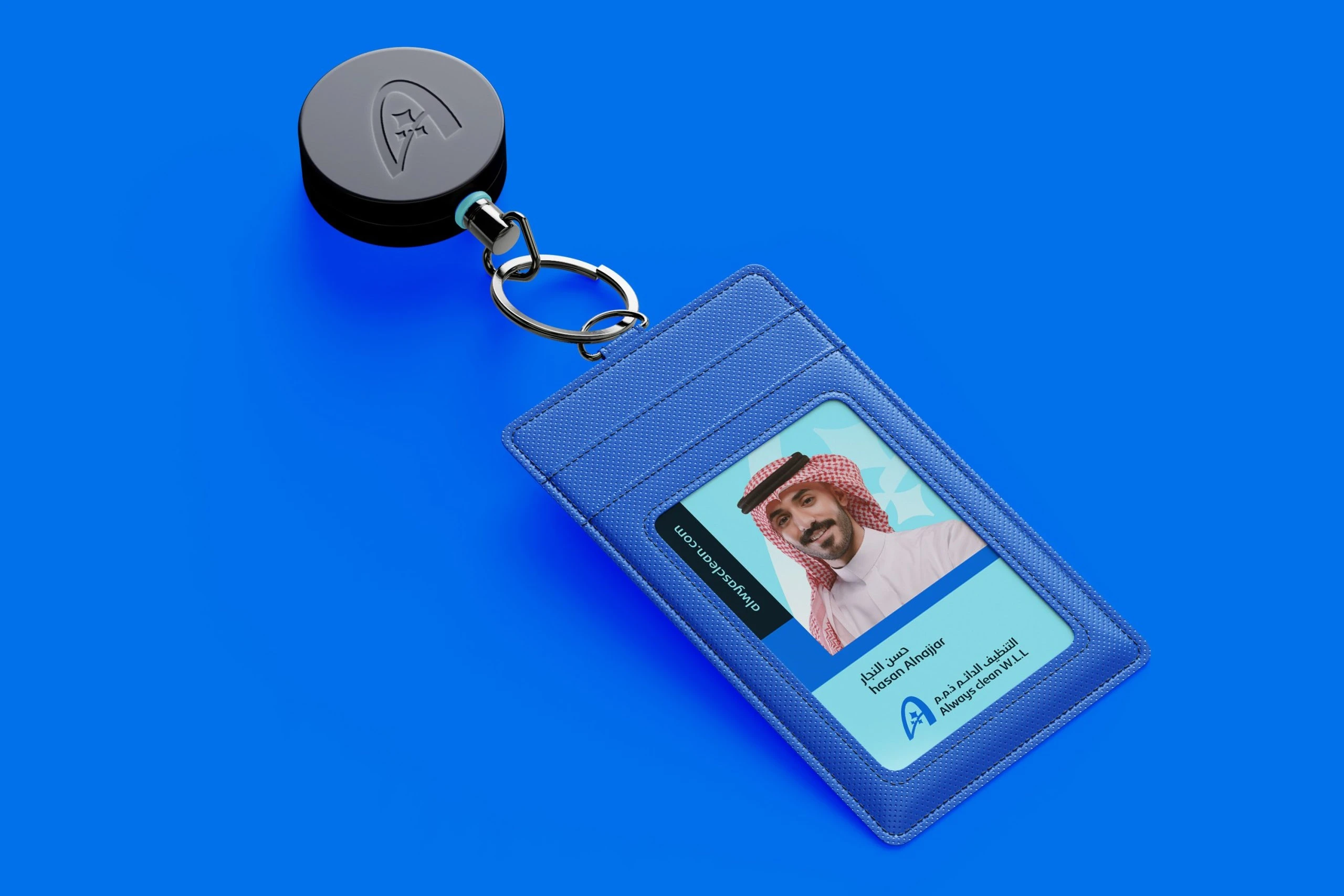 A blue staff ID card holder with a retractable reel on azure; the card shows a staff photo, a name in Arabic and English, and the Always Clean logo.