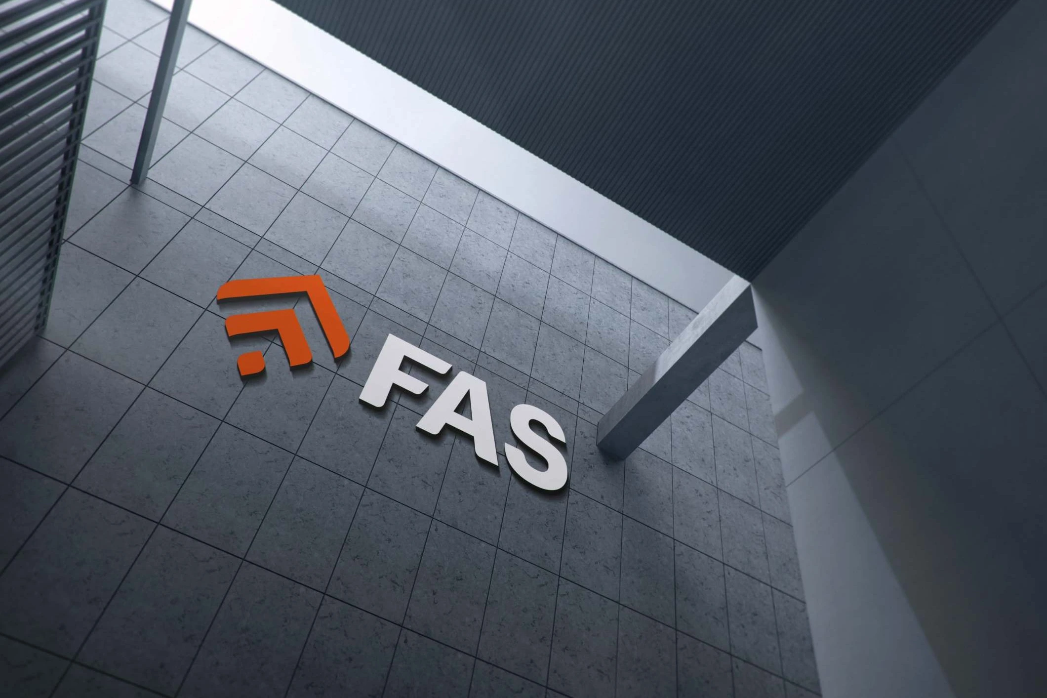 The FAS logo mounted as a sign on a grey tiled facade, orange mark and white letters, seen from below beside a concrete beam.