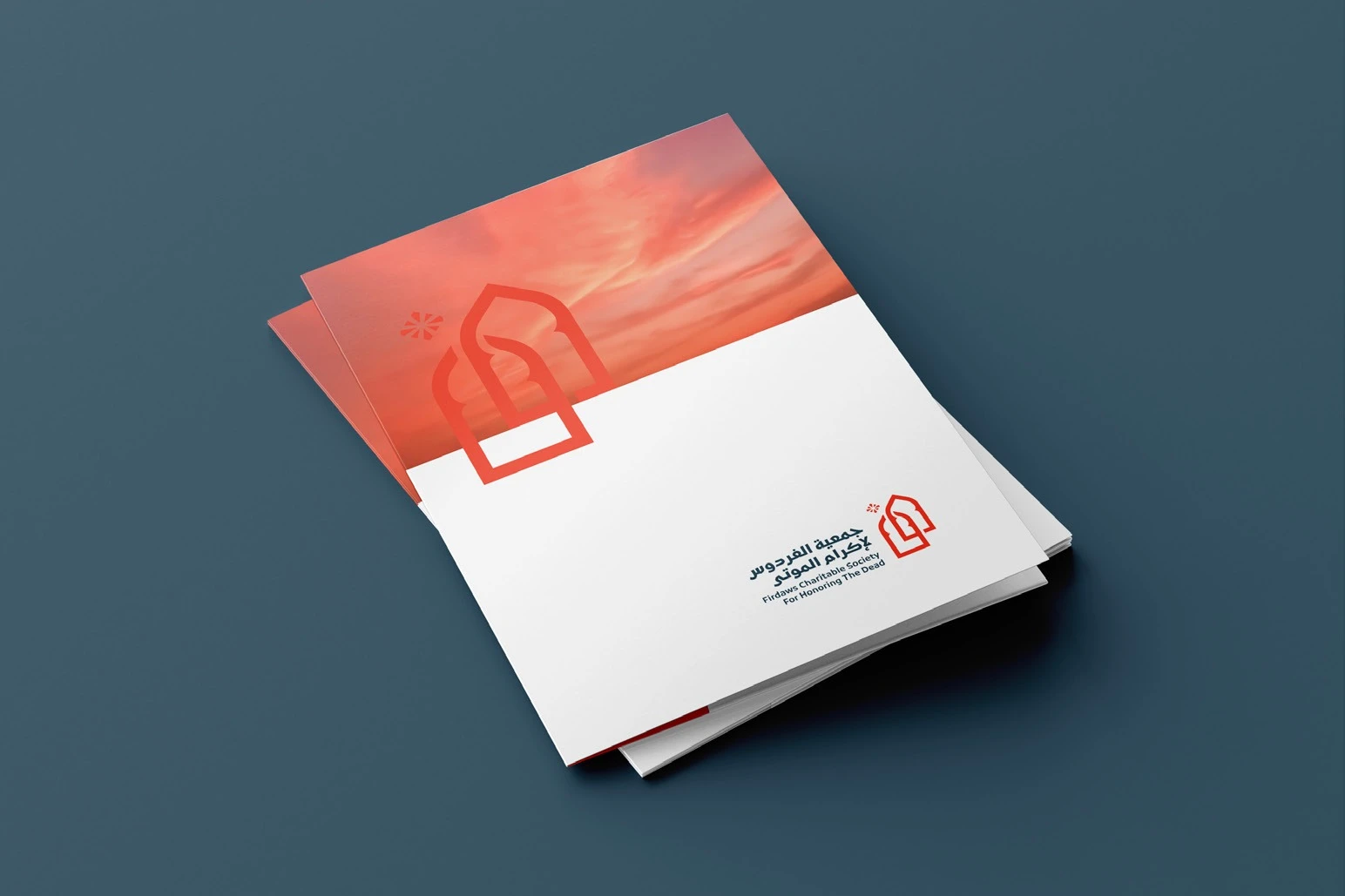 A folder whose cover shows the coral sky and arch above the logo, on slate.