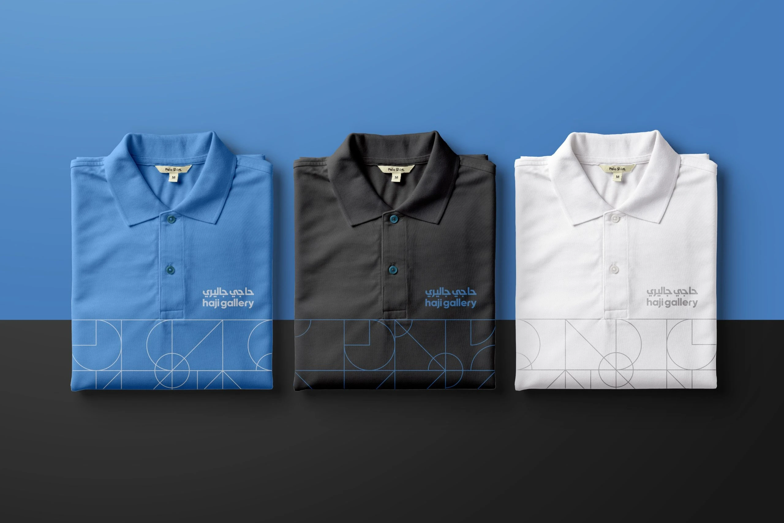Three folded polo shirts in blue, black and white, each with the logo on the chest and the line pattern along the hem.