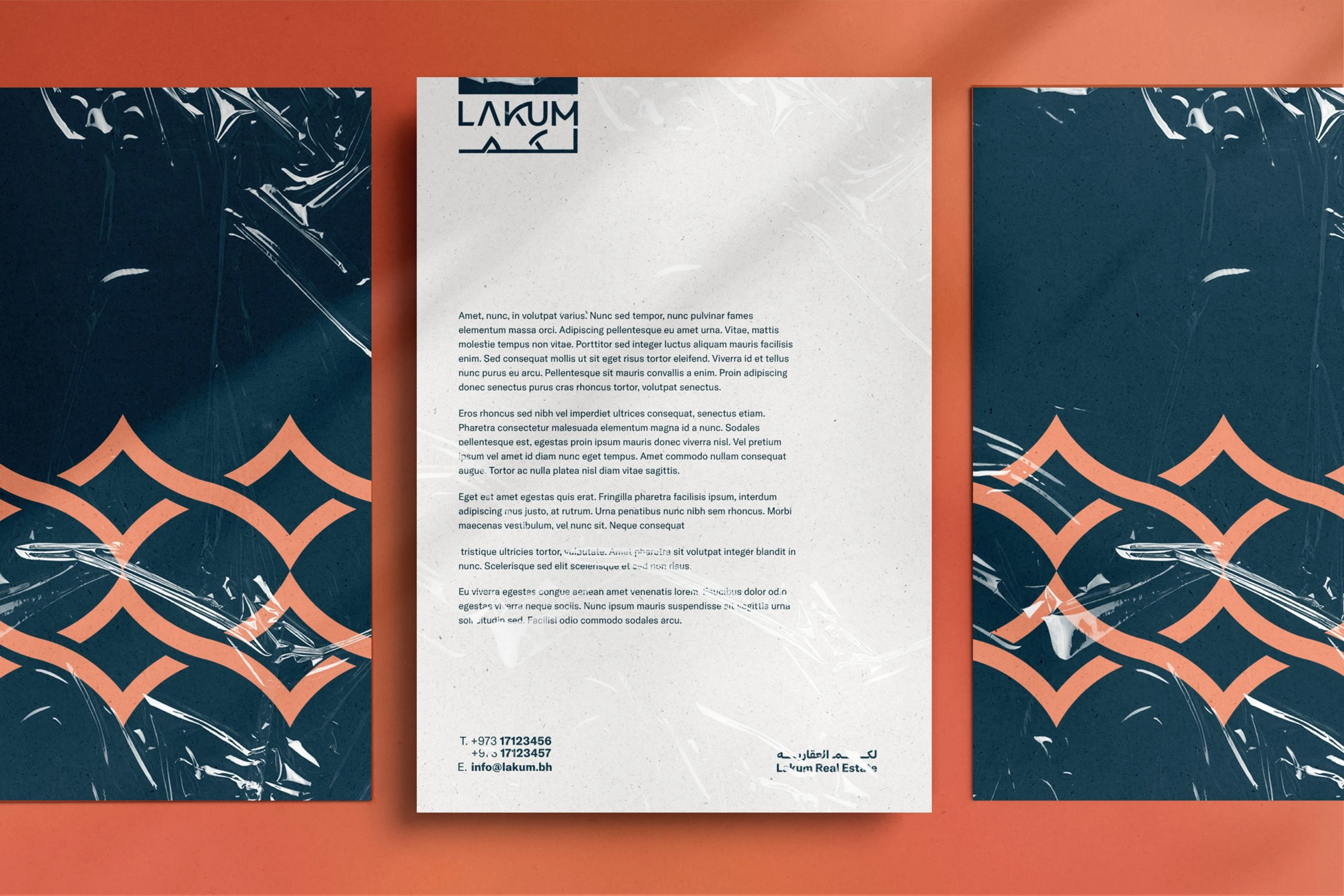 A Lakum letterhead with the bilingual wordmark on speckled off-white paper, between two deep blue sheets printed with the coral supportive element, on coral.