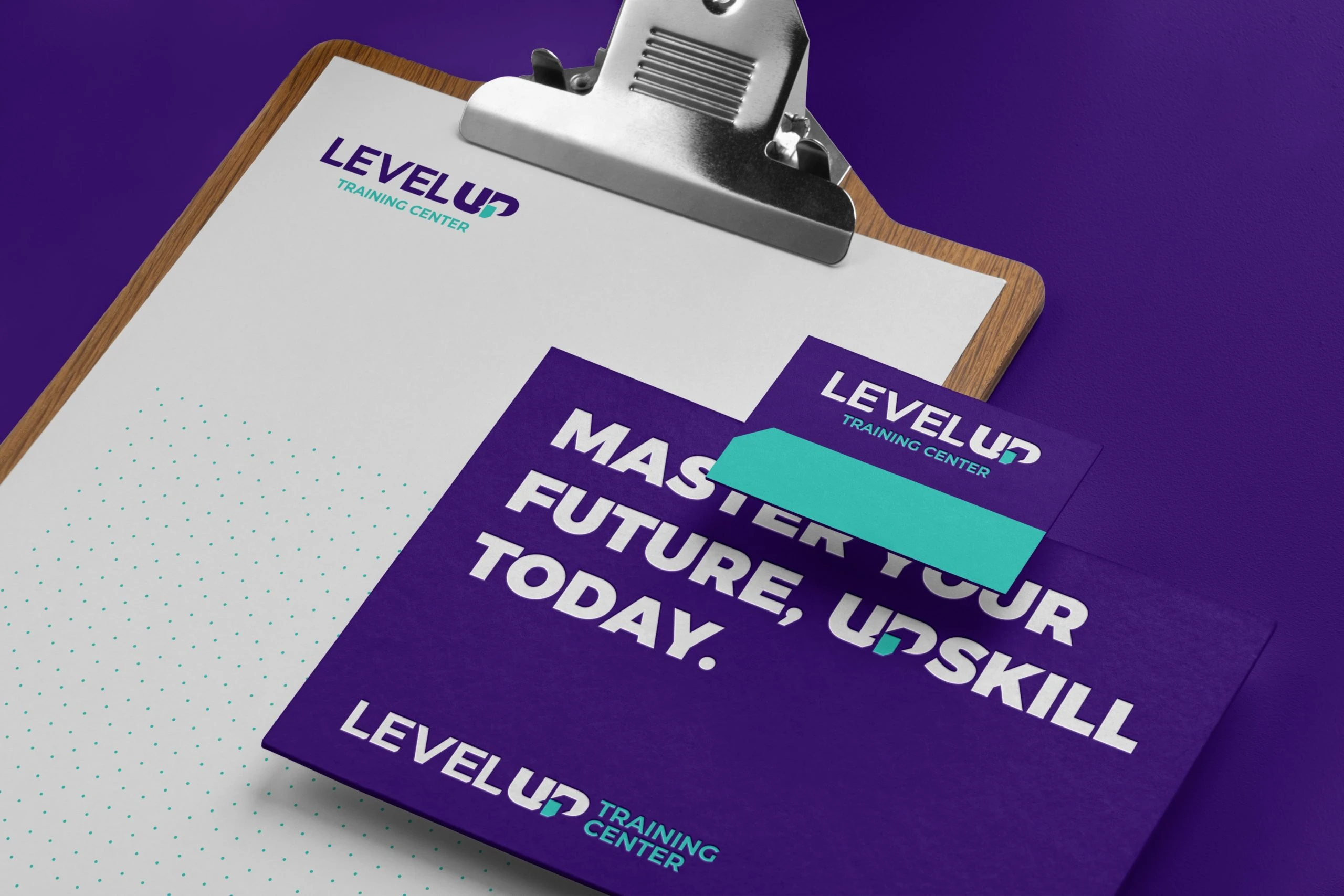 Level Up stationery on purple: a clipboard with a white letterhead and turquoise dot grid, a purple card reading Master your future, upskill today, and a smaller logo card.