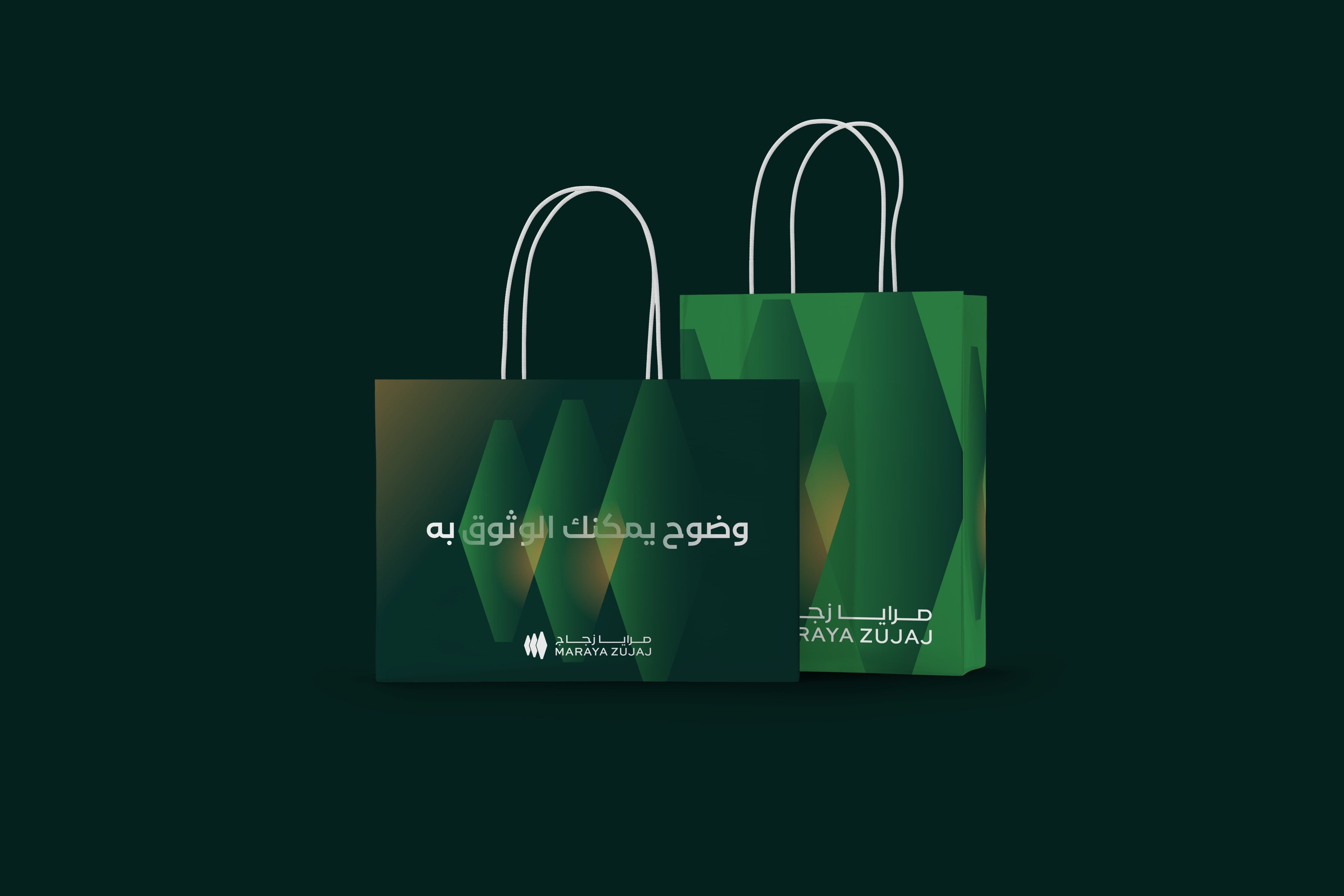 Two paper bags with white handles on deep green: a dark green bag with وضوح يمكنك الوثوق به and the logo, and a bright green bag with large hexagons.