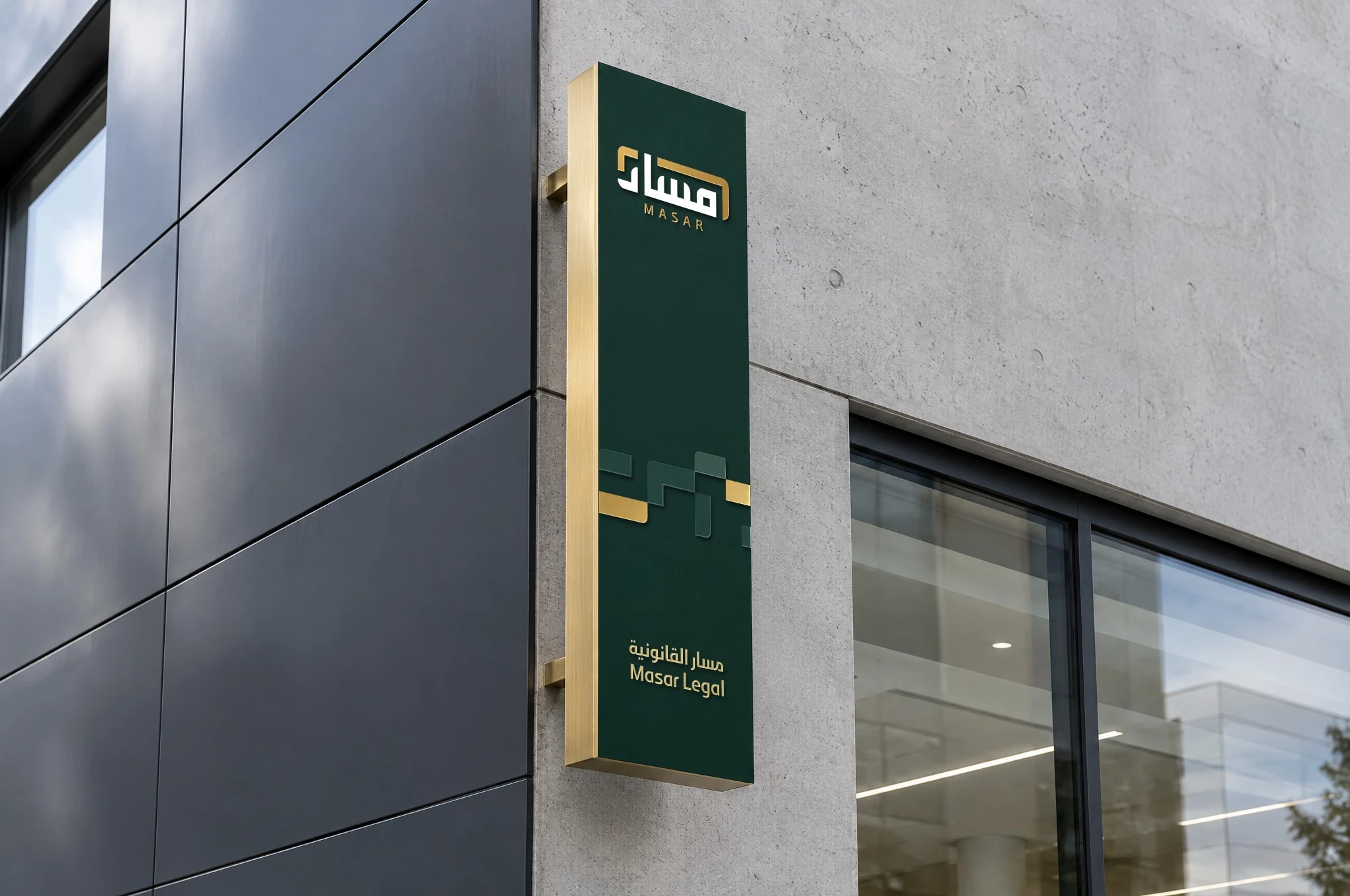 A narrow projecting sign at a building corner: a deep green face with the logo, the pattern and the logotype, framed in brushed gold.