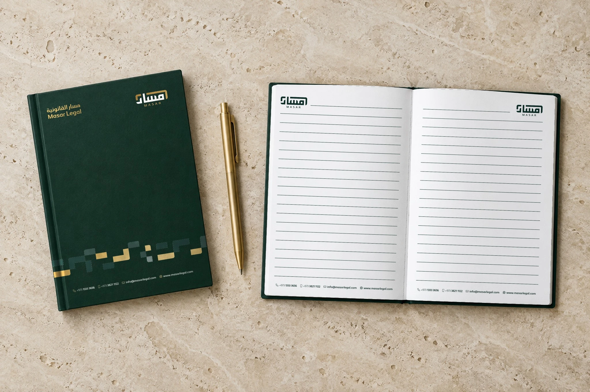 A closed Masar notebook beside an open one with ruled pages and the logo in the top corners, with a gold pen, on travertine.