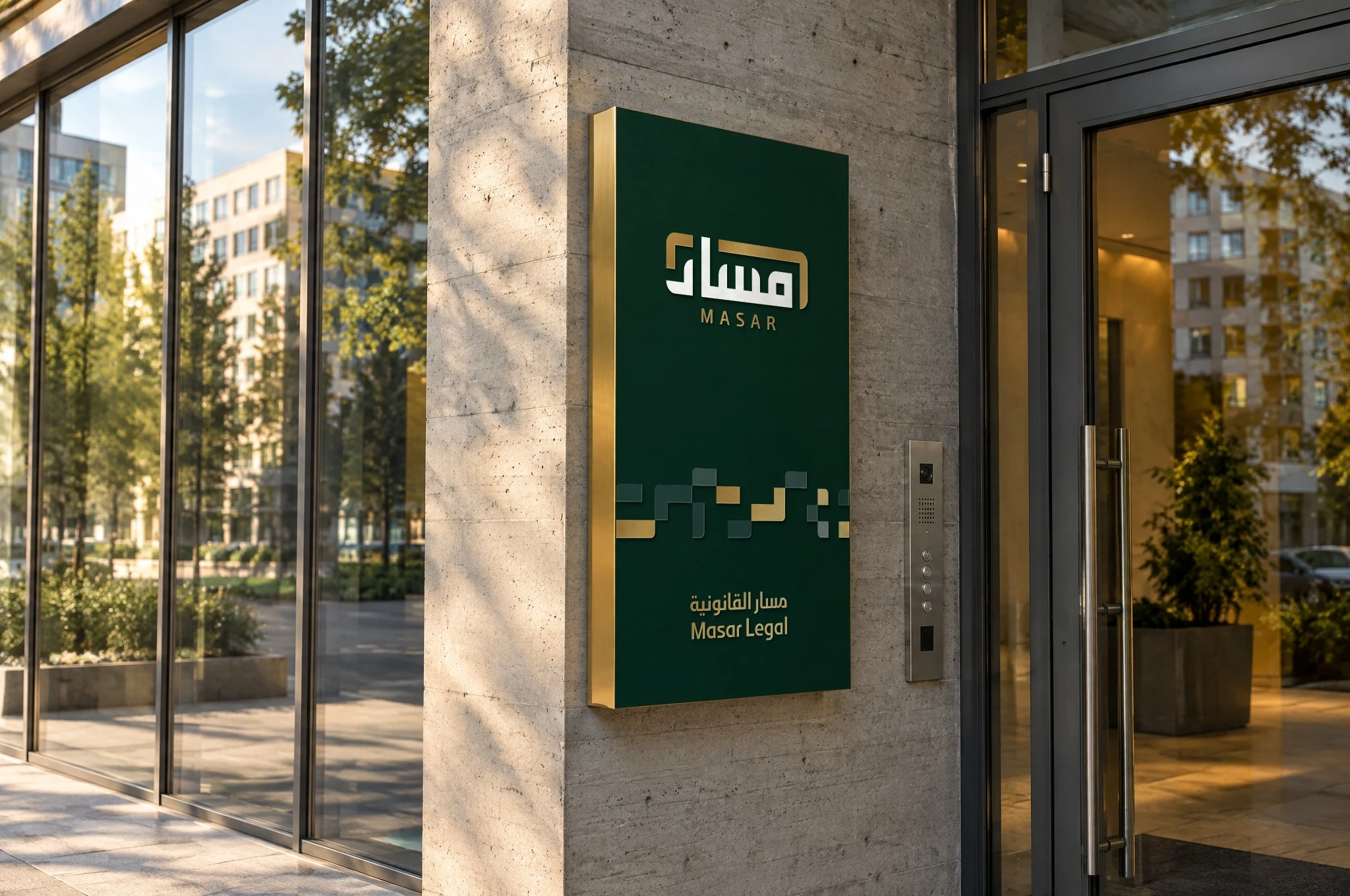 A deep green wall sign with gold edges on a concrete column beside a glass entrance, with the logo, the pattern and the logotype.