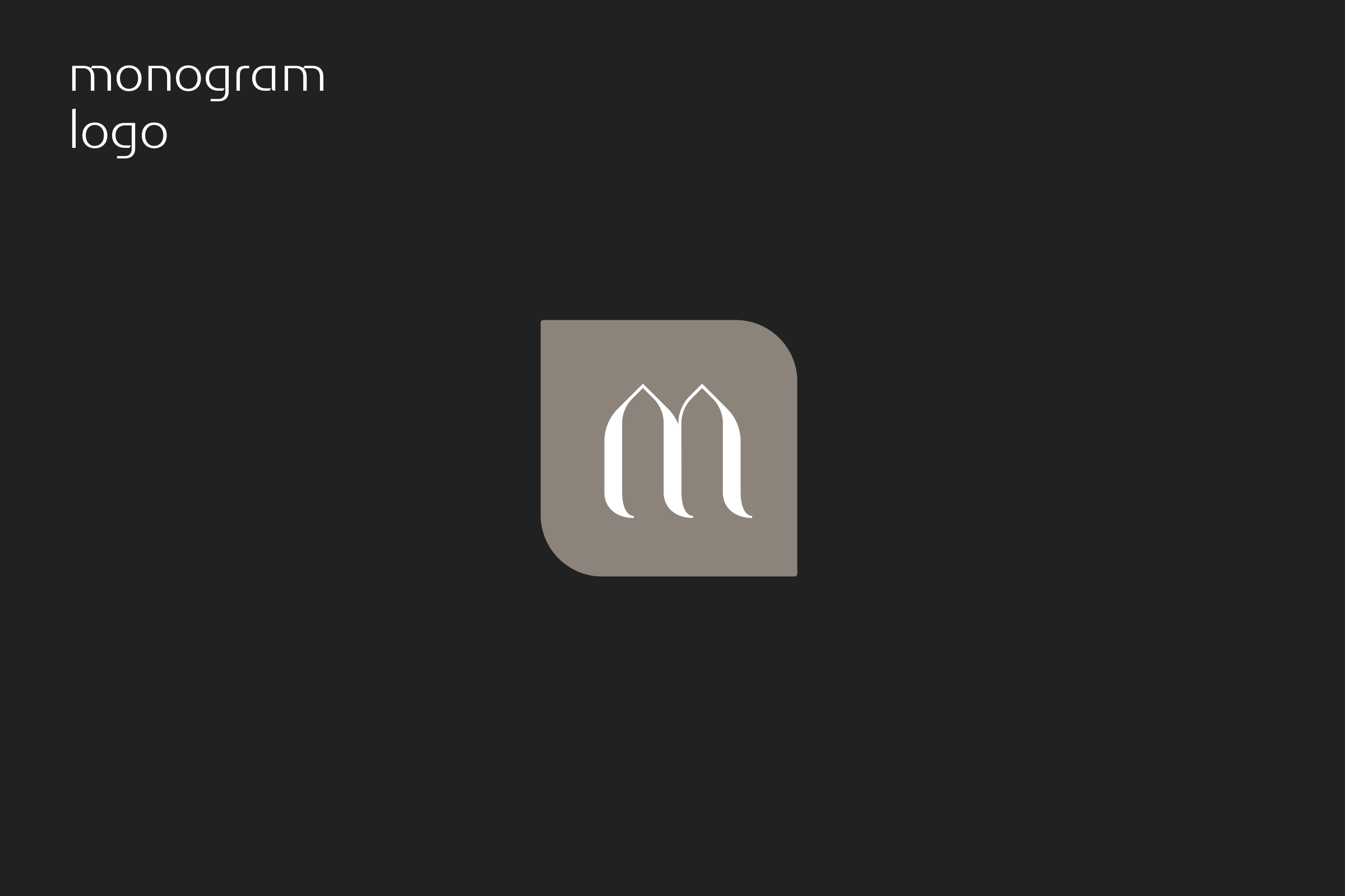 The monogram: the arched m in white on a taupe tile, on charcoal.