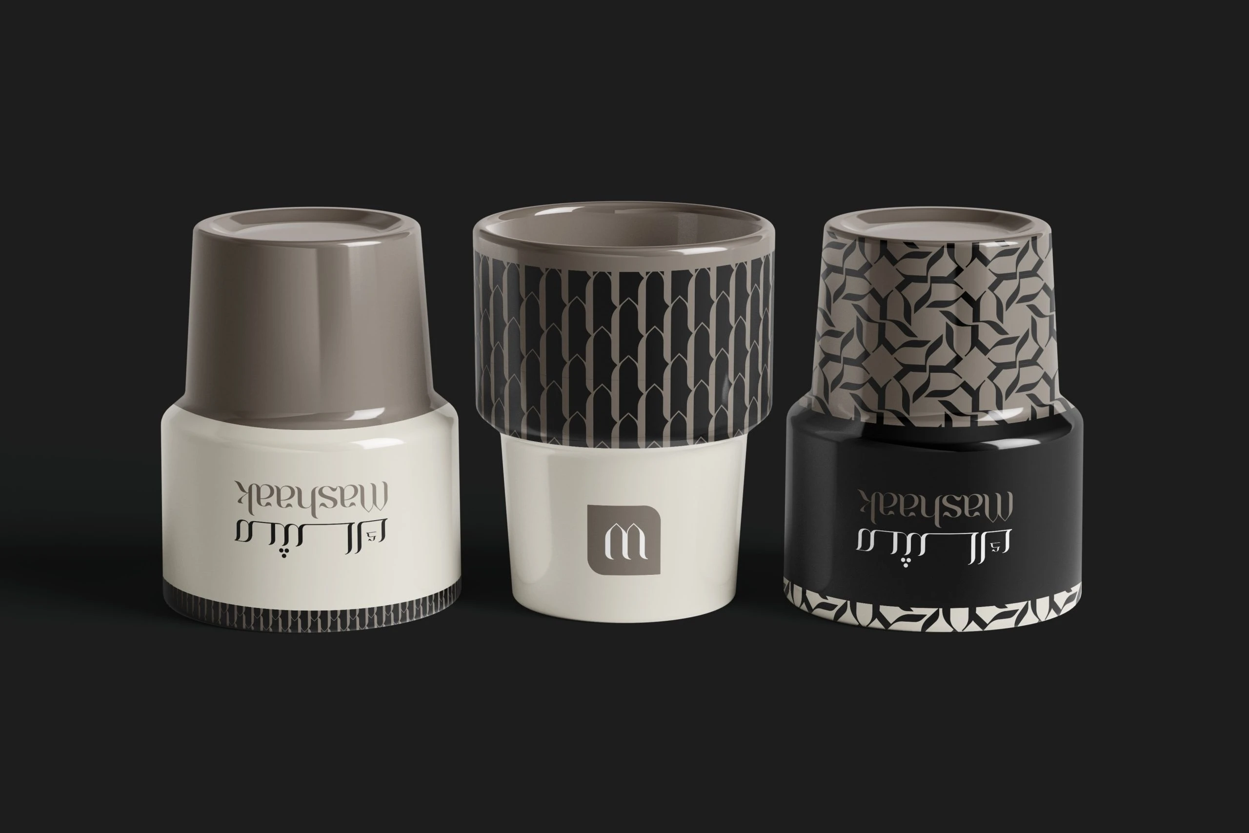 Three Mashaak ceramic mugs on charcoal, white, patterned and black, with the logotype, the monogram and the patterns.