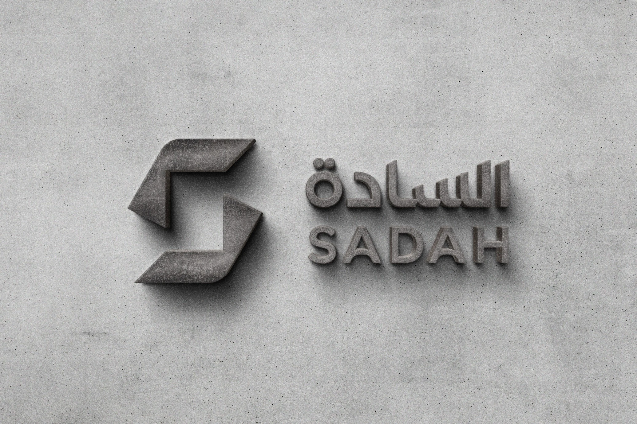 The Sadah logo cut in grey and standing out from a pale concrete wall.