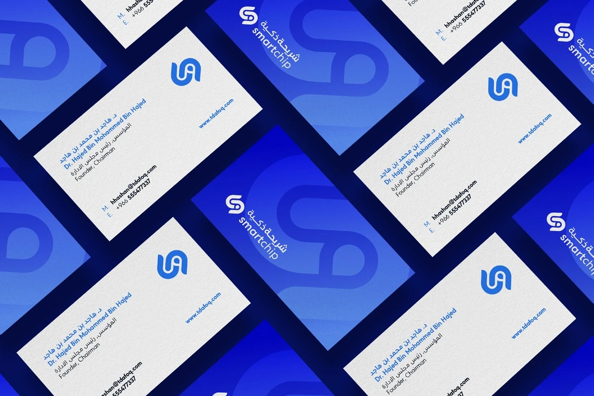 Rows of Smart Chip business cards, white fronts and blue backs with the monogram, laid diagonally.