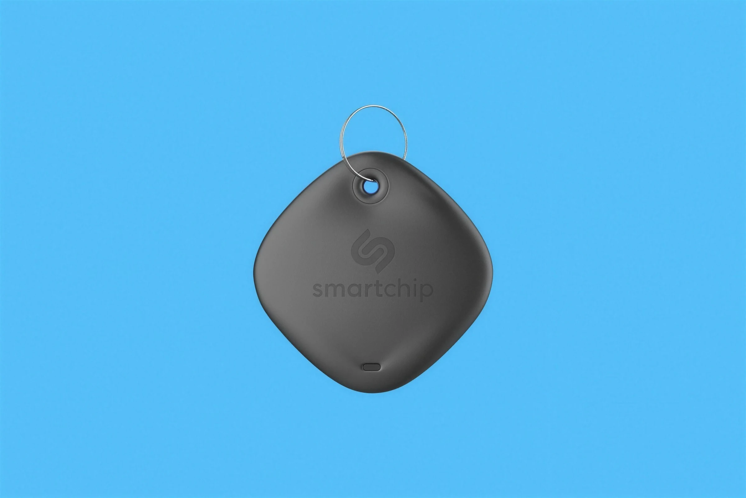 A black rounded-square tracker with the monogram and smartchip, on light blue.