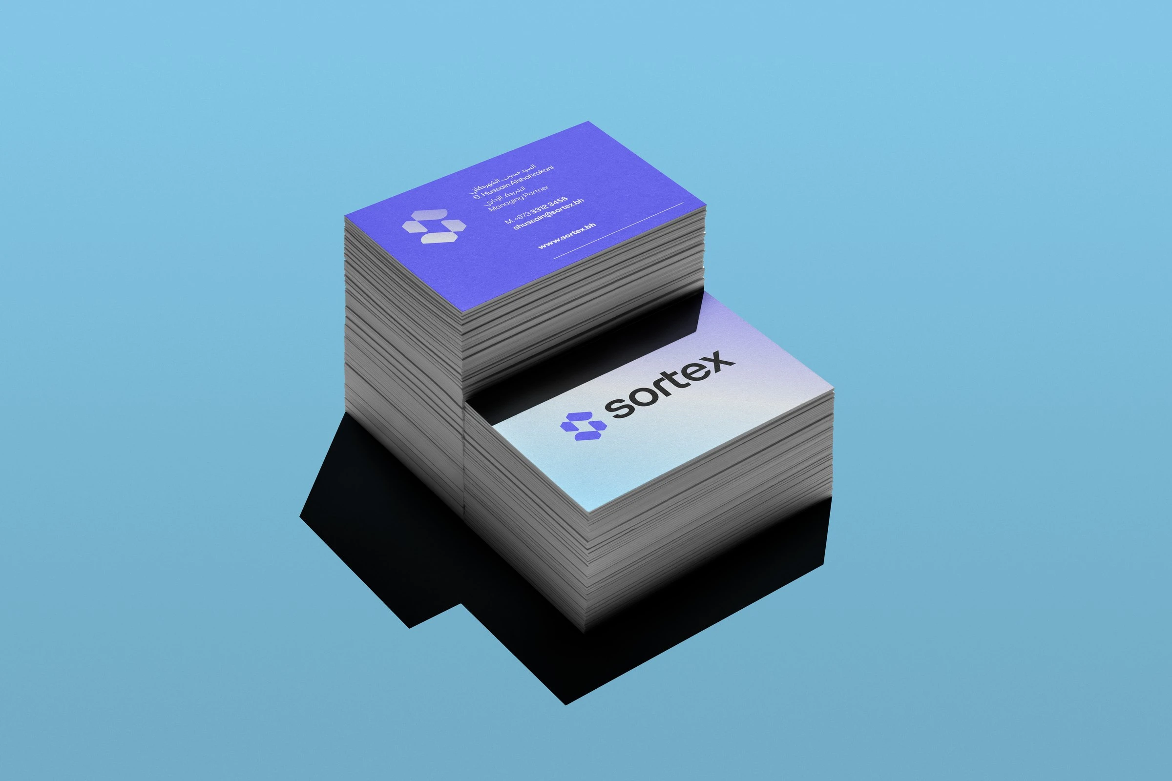 Two stacks of Sortex business cards, one violet and one in a pale gradient, on a blue background.