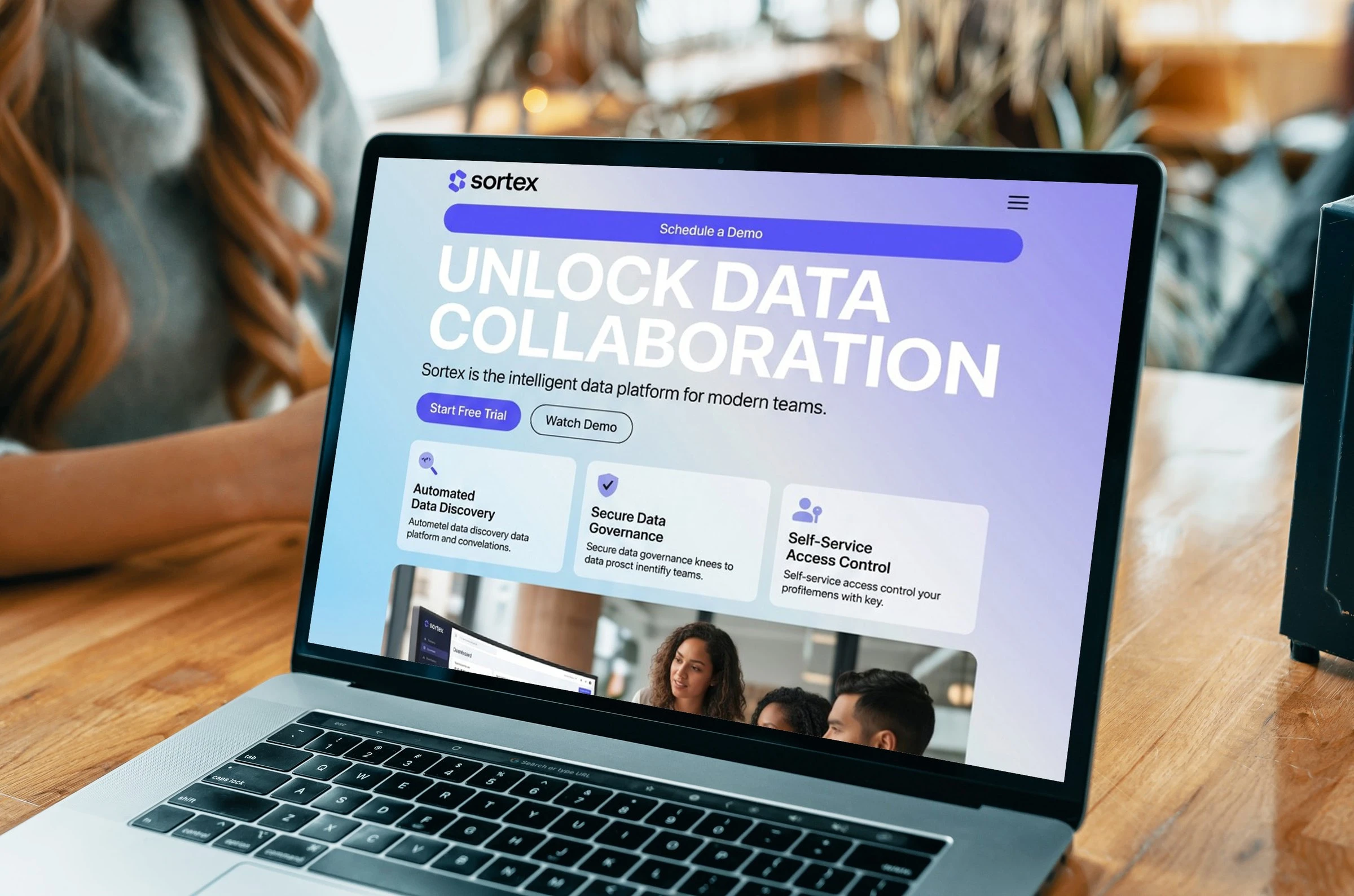 A laptop on a café table showing the Sortex website, headlined Unlock data collaboration.