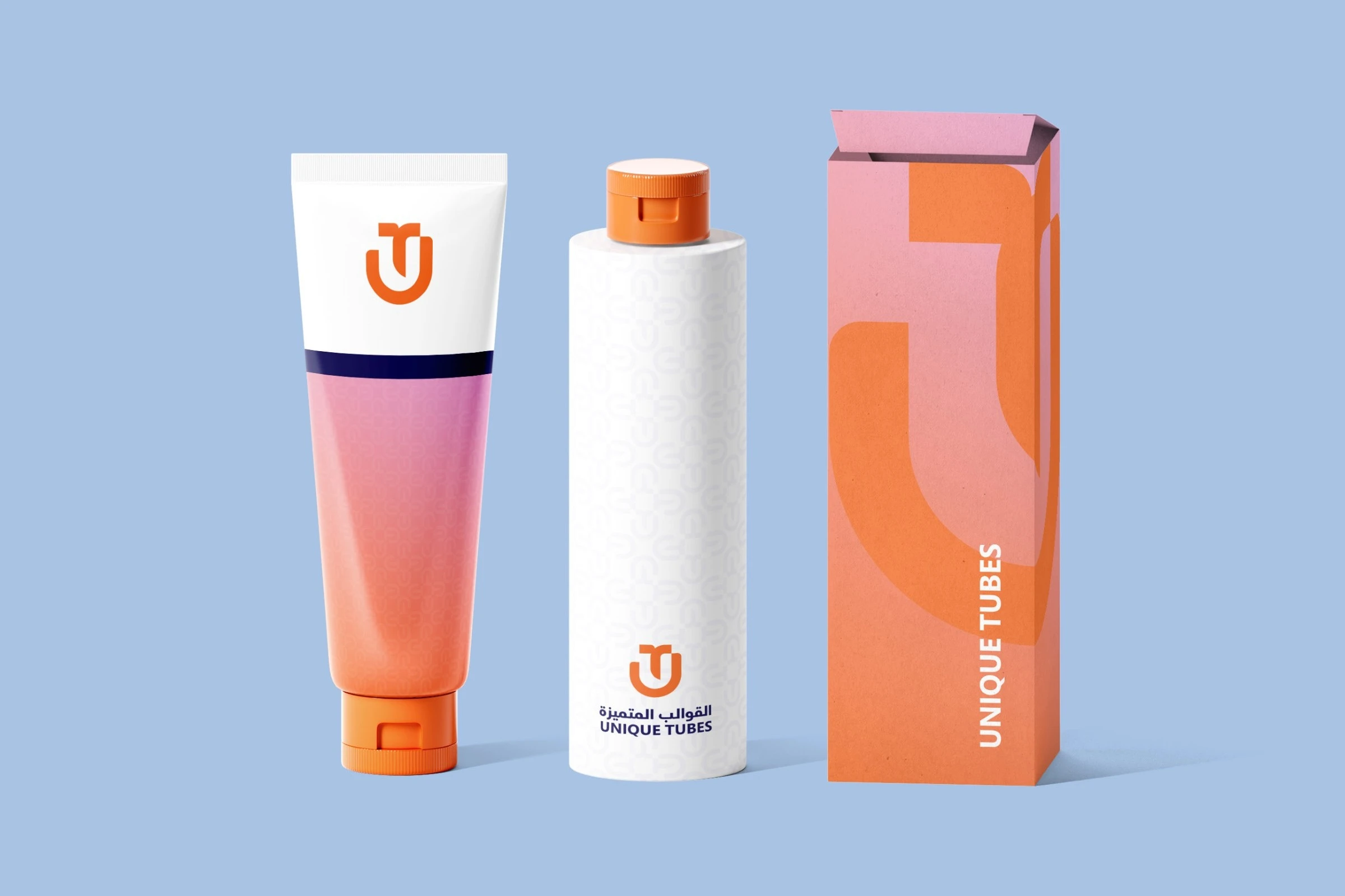 A squeeze tube with the monogram, a white bottle with a faint pattern and the logo, and a pink-to-orange box with UNIQUE TUBES running up its side, on pale blue.