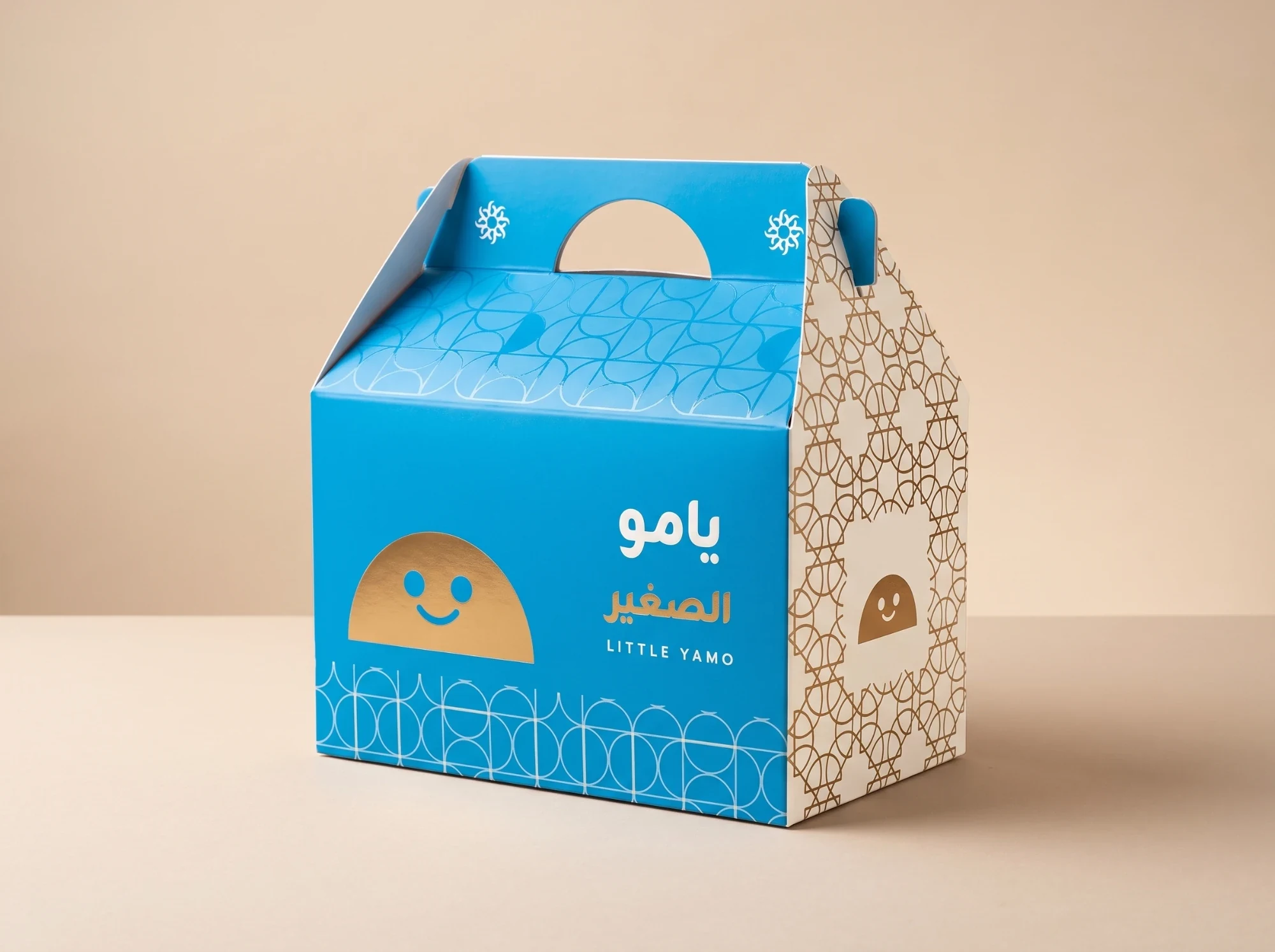 A blue carry box, يامو الصغير, LITTLE YAMO, with a gold half-moon character smiling through a cut-out window.